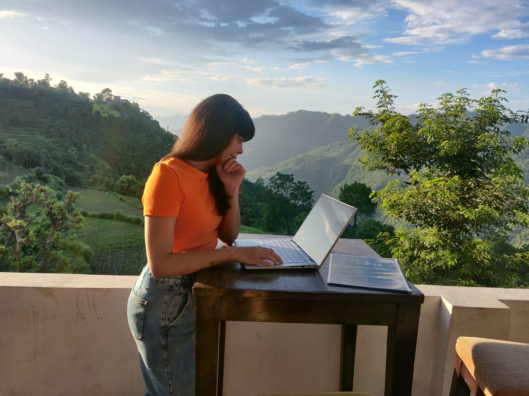 Woman on terrace with laptop on desk